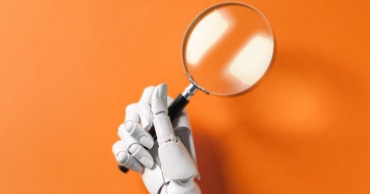 A white robotic hand holding a magnifying glass against an orange background, representing AI searching for local businesses